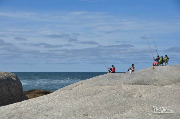 Pescadores na ponta de pedra na Punta del Diablo, no litoral do Uruguai